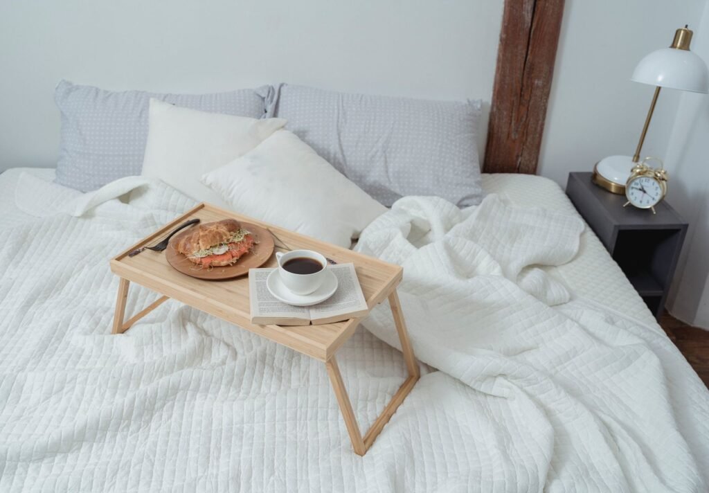Plateau de petit-déjeuner en bois sur un lit au linge blanc