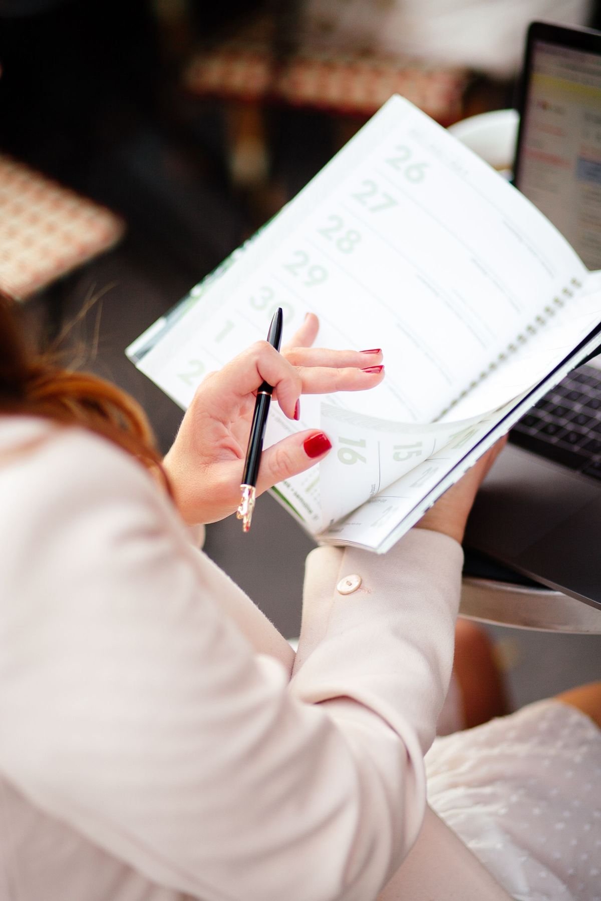 Main notant un planning dans un agenda